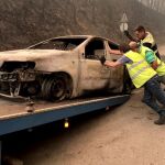 Pperarios retiran un coche calcinado en el incendio