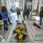 Visitantes de la catedral observan las flores depositadas en el enterramiento de la familia Franco en la catedral de la Almudena