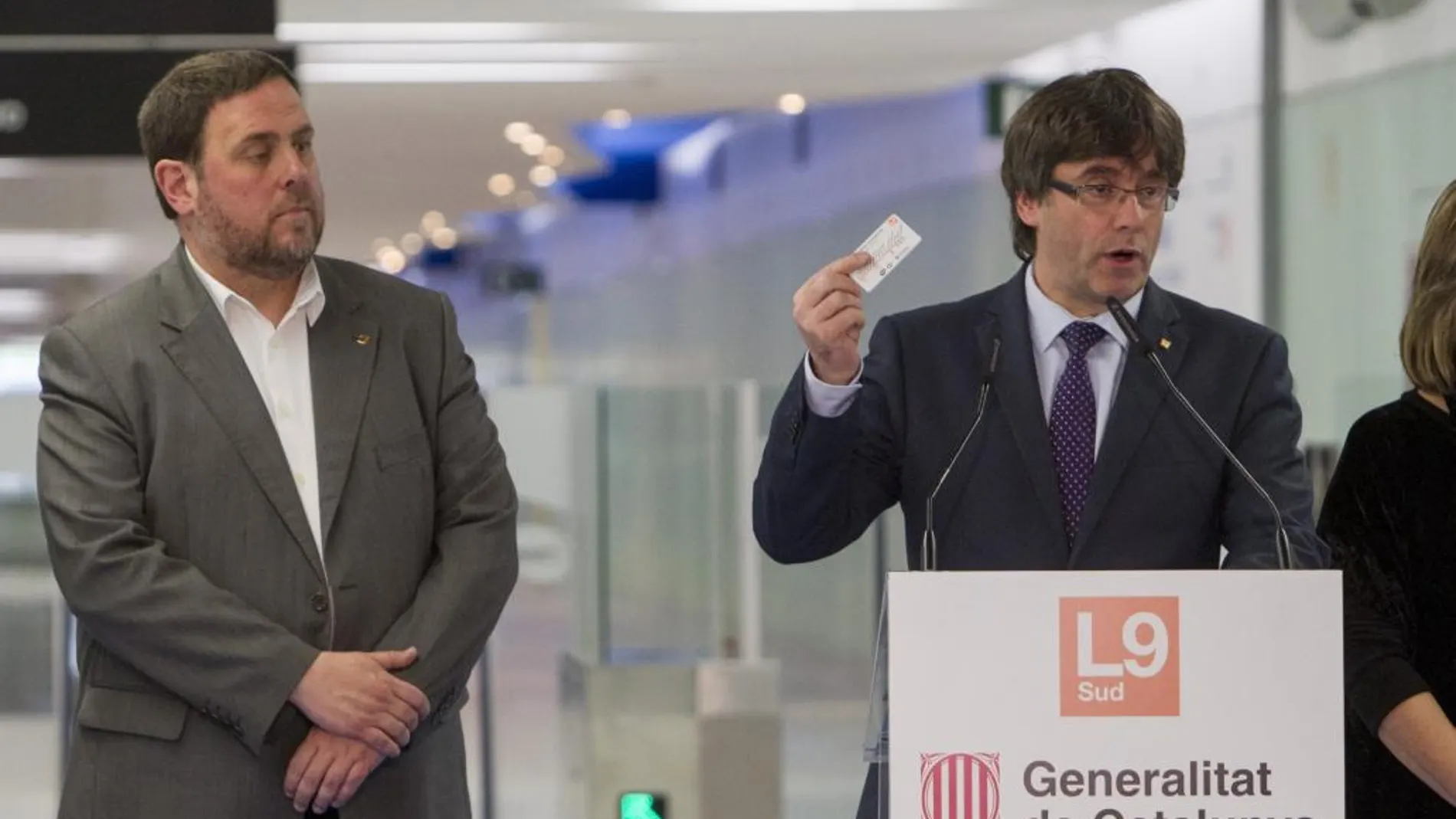 El president de la Generalitat, Carles Puigdemont (d), acompañado del vicepresidente del Gobierno catalán, Oriol Junqueras (i), en el aeropuerto del Prat, durante la inauguración del nuevo tramo de la línea 9 del metro de Barcelona