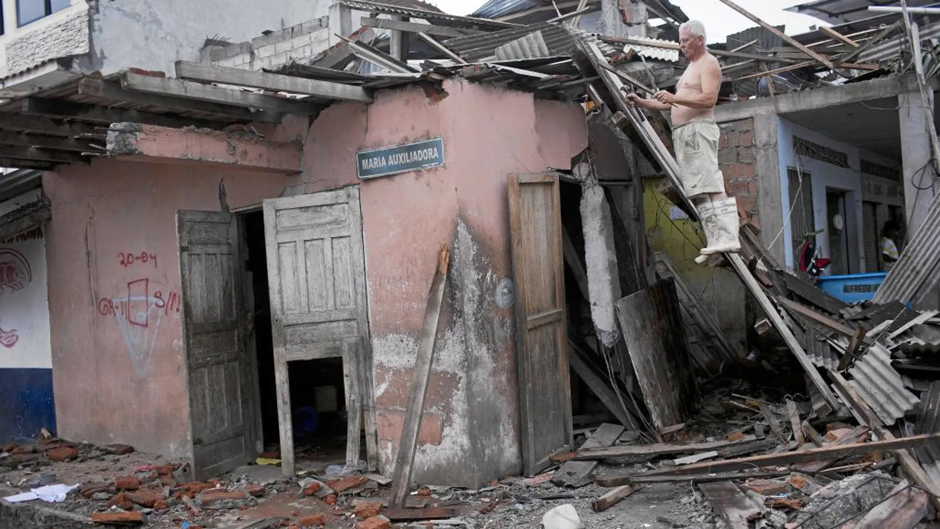 Un hombre trata de salvar algo de madera del tejado de su hogar en Pedernales (Ecuador), destrozado tras el terremoto del pasado 16 de abril