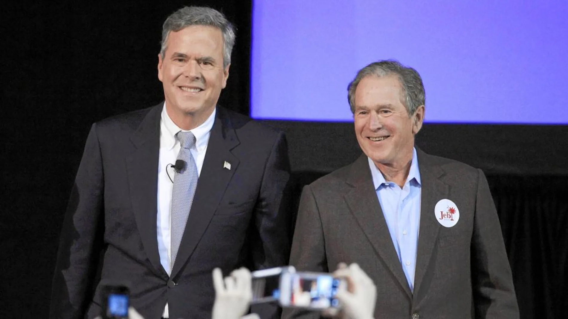 El ex presidente George W. Bush acompaña a su hermano, ayer, en un mitin