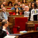 La lider de Ciutadans, Inés Arrimadas, enseña unas fotos de lazos amarillos en edificios públicos al presidente de la Generalitat, Quim Torra (i), durante su intervención en el pleno del Parlament