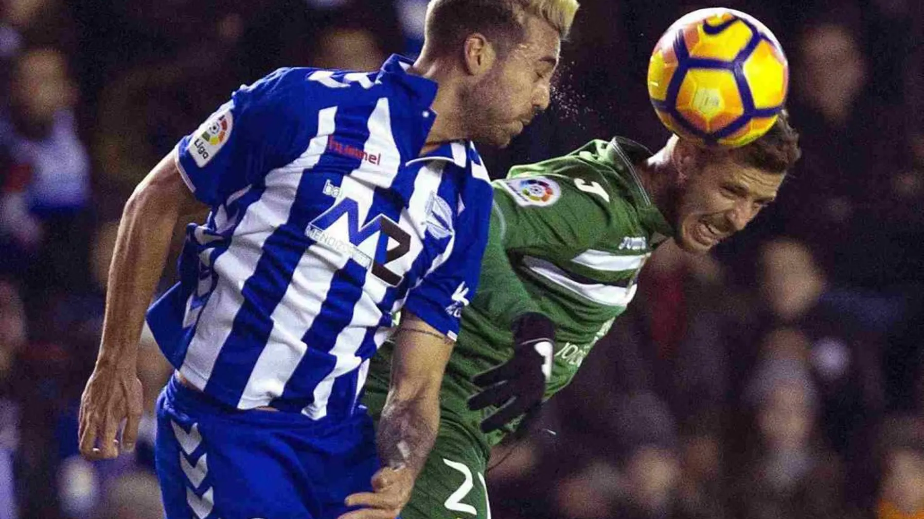 El centrocampista del Alavés Víctor Camarasa (i) salta a por un balón con Raúl Pérez, del Leganés.