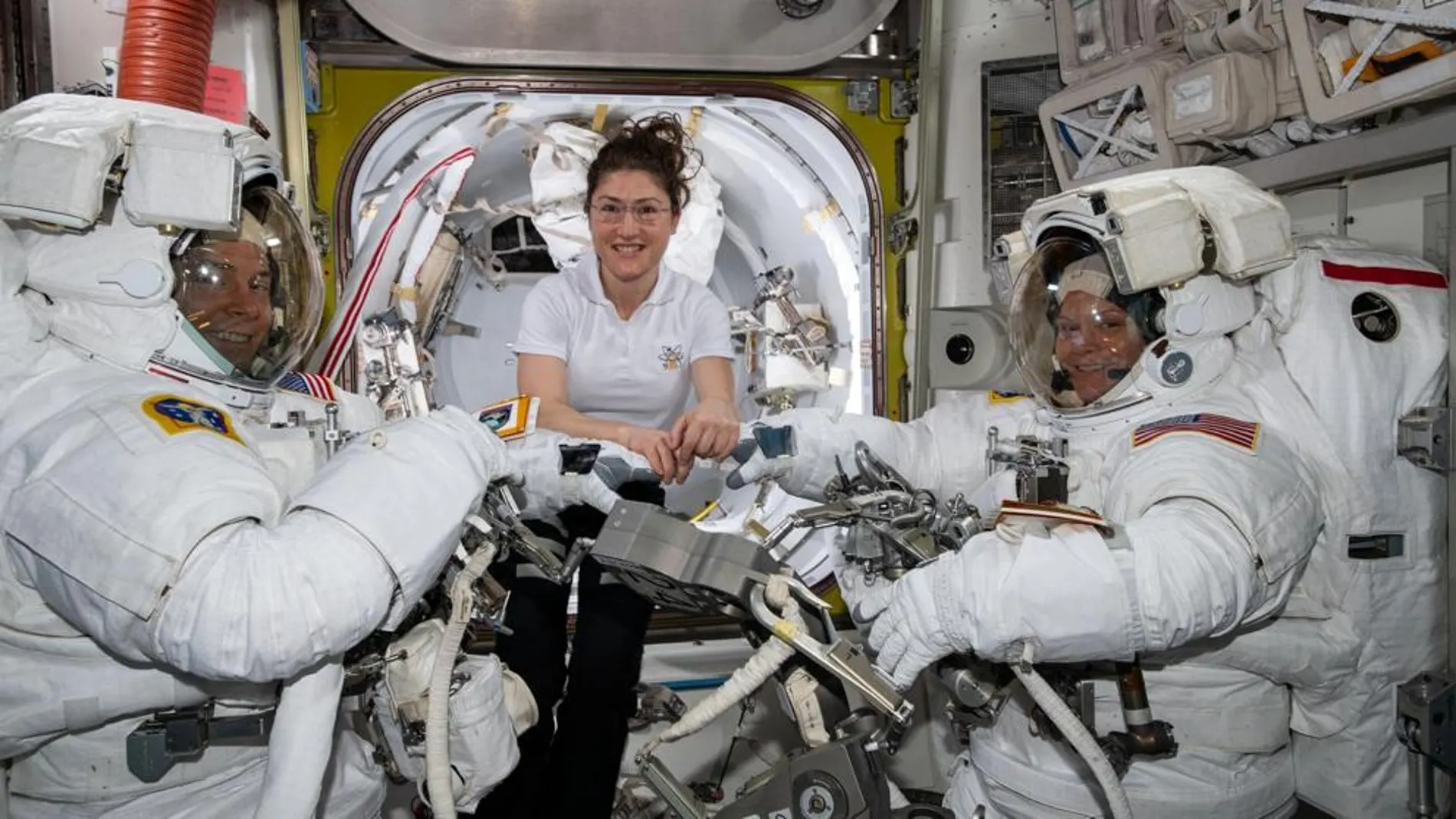 Los astronautas de la NASA Nick Hague (izquierda) y Anne McClain (derecha), preparándose para el paseo espacial del pasado viernes 22 de marzo, asistidos por Christina Koch (centro) / NASA