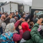 Migrantes reciben ayuda en un campo de refugiados de Idomeni (Grecia), próximo a la frontera con Macedonia