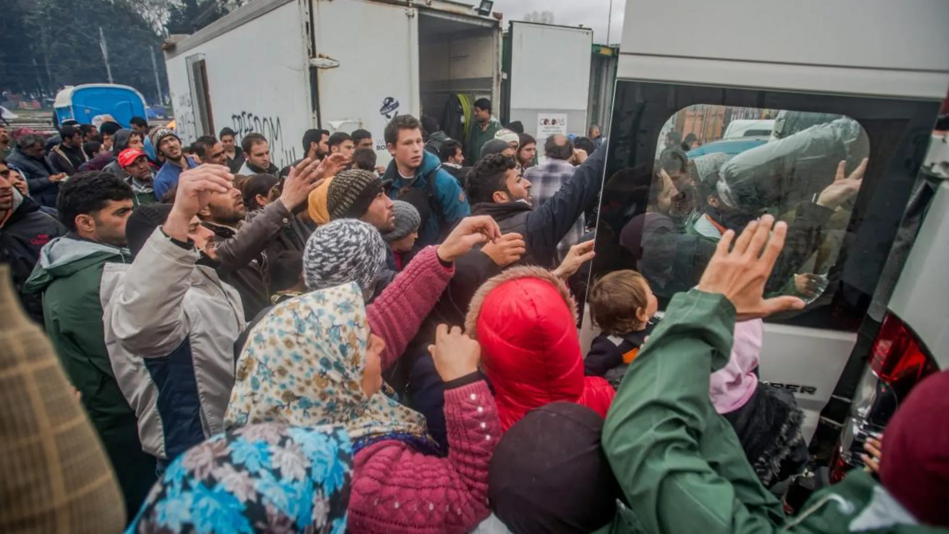 Migrantes reciben ayuda en un campo de refugiados de Idomeni (Grecia), próximo a la frontera con Macedonia