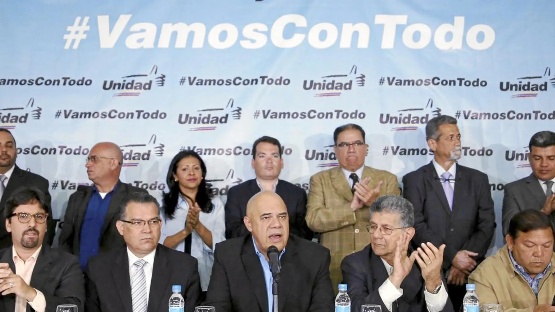 Jesus Torrealba (C), secretary of Venezuela's coalition of opposition parties (MUD), talks to the media next to his fellow politicians during a news conference in Caracas March 8, 2016. The message on the backdrop reads: "With the people and the constitution, we are going with everything". REUTERS/Carlos Garcia Rawlins