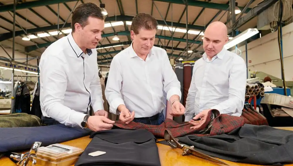 Tres de los cinco socios de Antonaga hacen la última prueba de calidad a una americana para comprobar las costuras y caída de la tela.