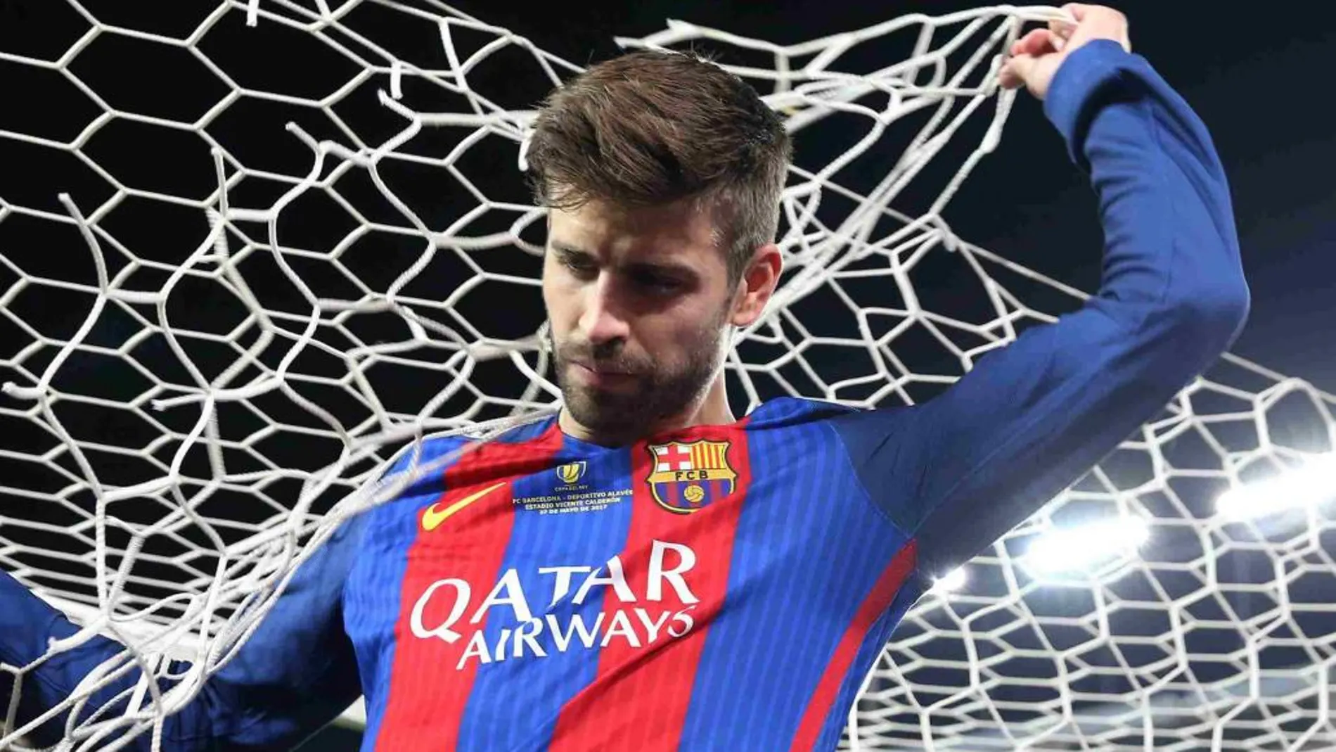 Gerard Pique corta la red tras ganar la Copa del Rey.