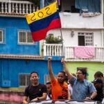 Freddy Guevara, integrante del partido de Guaidó y Leopoldo López (c-d), sostiene una bandera mientras participa en una manifestación en Caracas