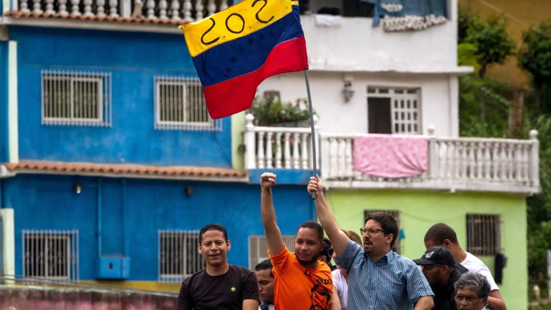 Freddy Guevara, integrante del partido de Guaidó y Leopoldo López (c-d), sostiene una bandera mientras participa en una manifestación en Caracas