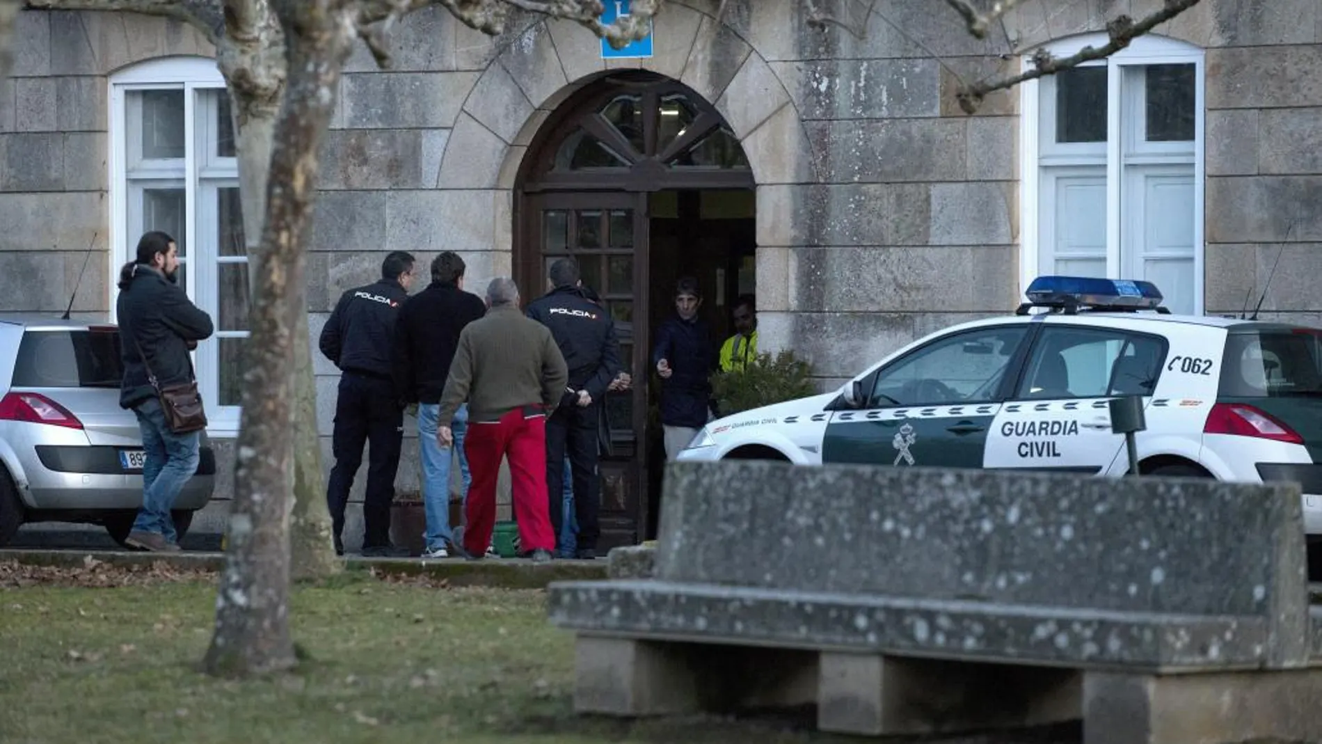 Efectivos de la Policía y familiares de los fallecidos ante el hostal en el que un hombre de 61 años ha matado a su padre en Baños de Molgas (Ourense) y posteriormente se ha quitado la vida.