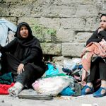 Las más vulnerables. Dos mujeres sentadas en la calle con sus pertenencias tras ser destruida su casa por ataques israelíes. Foto: Reuters
