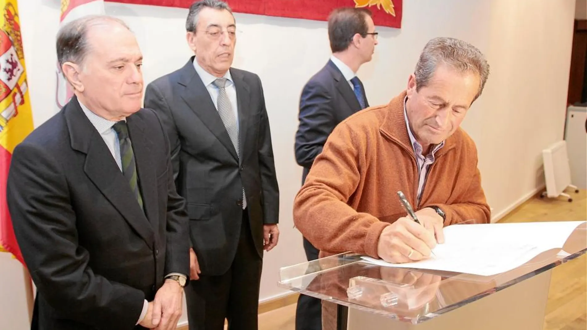 Tomás Villanueva observa como uno de los alcaldes firma, en presencia de Bienvenido Mena y Germán Barrios