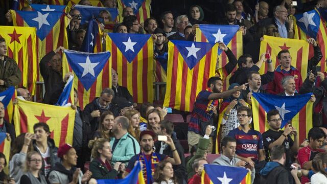 Varias personas sostienen esteladas durante el encuentro de la cuarta jornada de la fase de grupos de la Liga de Campeones que el FC Barcelona y el Bate Borisov disputan esta noche en el Camp Nou, en Barcelona