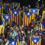Varias personas sostienen esteladas durante el encuentro de la cuarta jornada de la fase de grupos de la Liga de Campeones que el FC Barcelona y el Bate Borisov disputan esta noche en el Camp Nou, en Barcelona