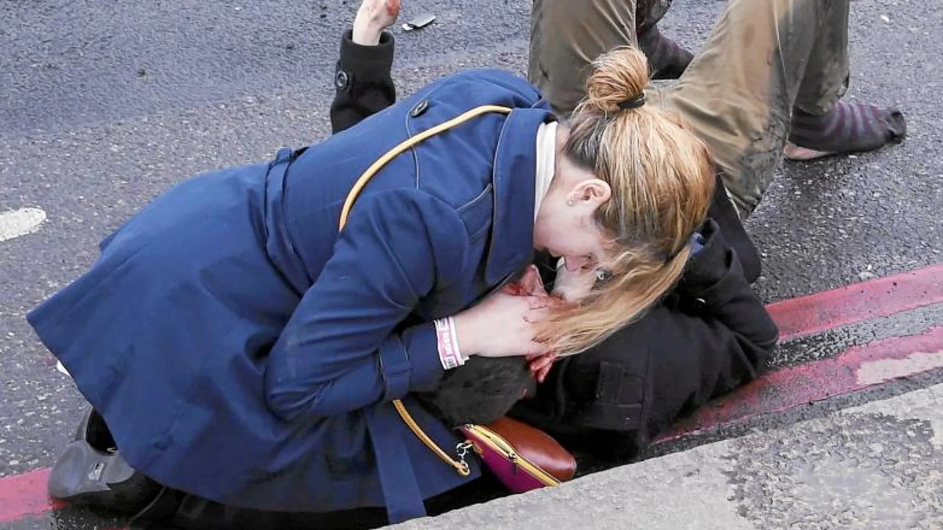 Una joven atiende a una de los heridos en el ataque terrorista en el puente de Westminster