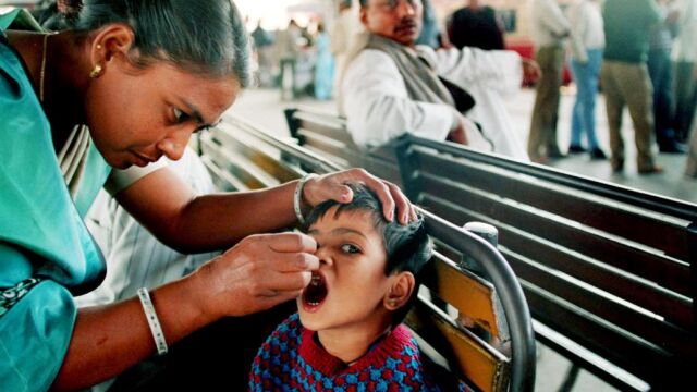 Una mujer suministra la vacuna contra la polio en India
