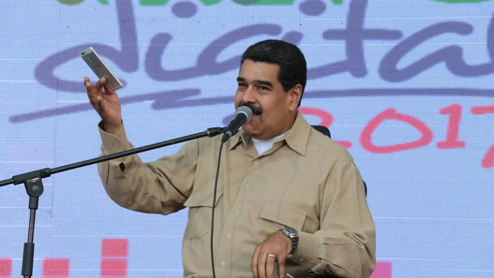 Fotografía cedida por el Palacio de Miraflores del presidente de Venezuela, Nicolás Maduro (i), hablando durante un acto con simpatizantes transmitido por la televisión estatal VTV