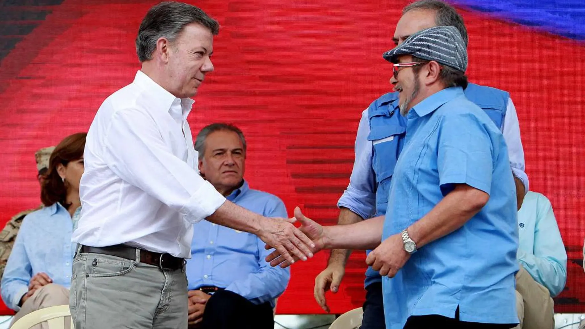 El presidente de Colombia, Juan Manuel Santos (i), estrecha la mano del máximo líder de las FARC, Rodrigo Londoño, alias Timochenko (d)