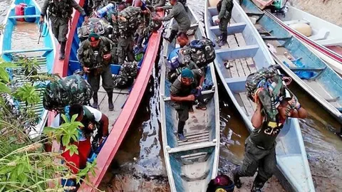Guerrilleros del Bloque Sur de las FARC atraviesan el río Mecaya para desmovilizarse