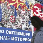 Una mujer pasa por delante de un cartel electoral en la capital, Skopje, en el que se pide el voto del «sí» para que Macedonia pueda entrar en la UE