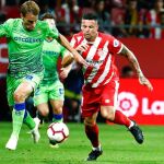 El centrocampista del Betis, Sergio Canales (i), conduce el balón ante el jugador del Girona FC, Francisco Aday Benítez