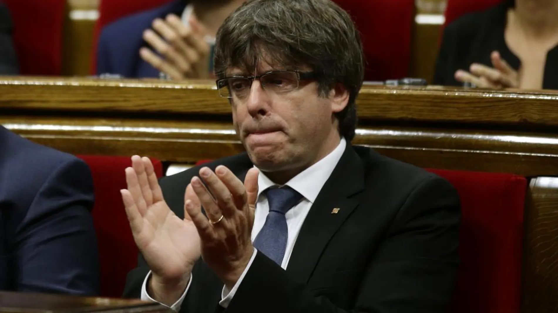 Carles Puigdemont aplaude tras el minuto de silencio en el Parlament