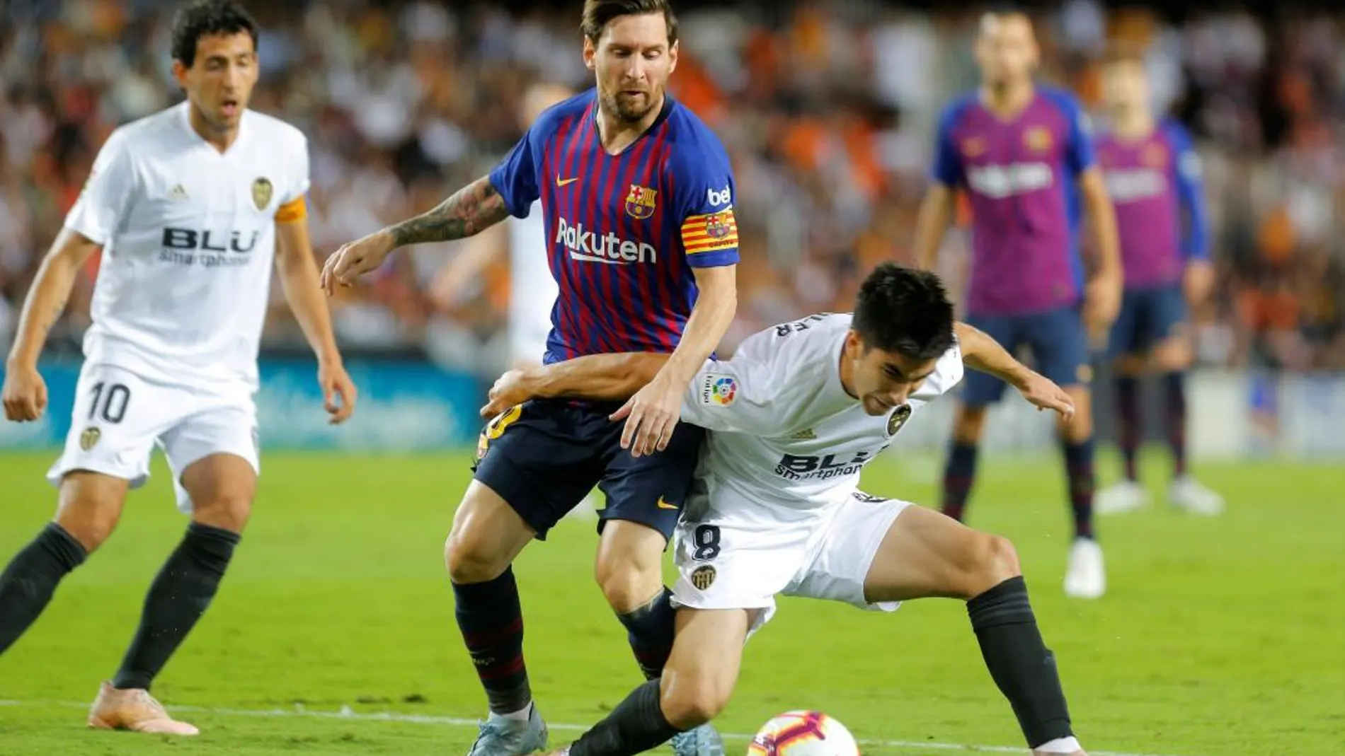 Messi disputa un balón en presencia de varios jugadores valencianistas / Efe