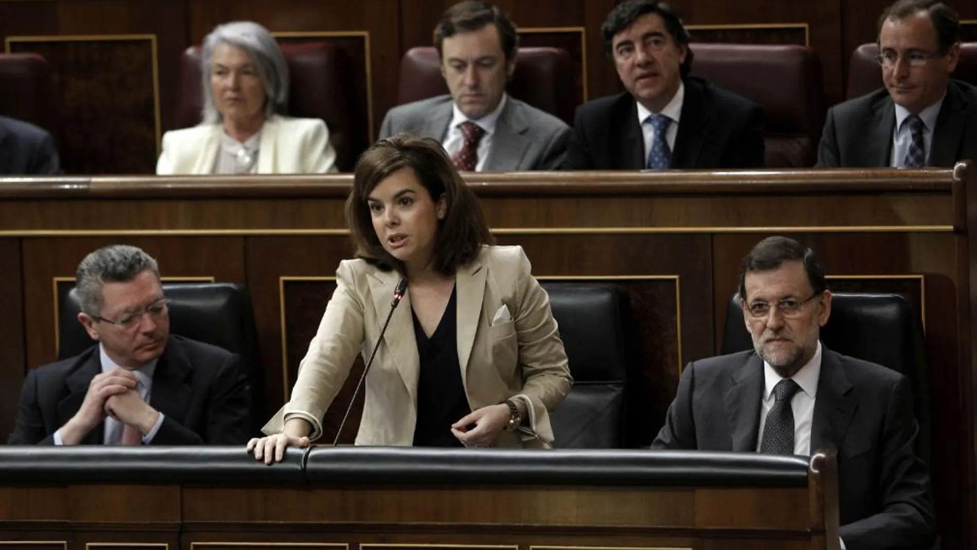 La vicepresidenta del Gobierno, Soraya Sáenz de Santamaría, junto al presidente, Mariano Rajoy y el ministro de Justicia, Alberto Ruiz Gallardón, durante su intervención en la sesión de control al Ejecutivo, esta mañana en el Congreso de los Diputados.