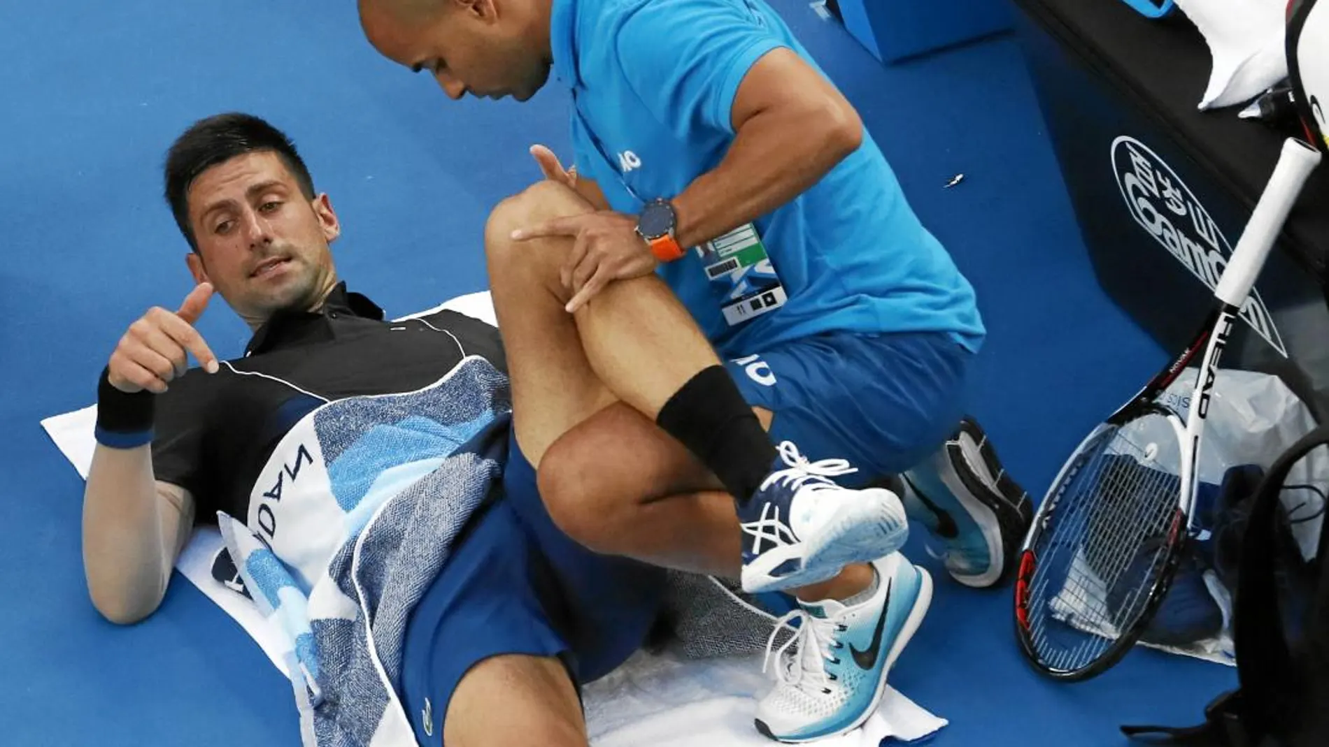 Novak Djokovic es tratado por su entrenador en la tercera ronda del torneo australiano