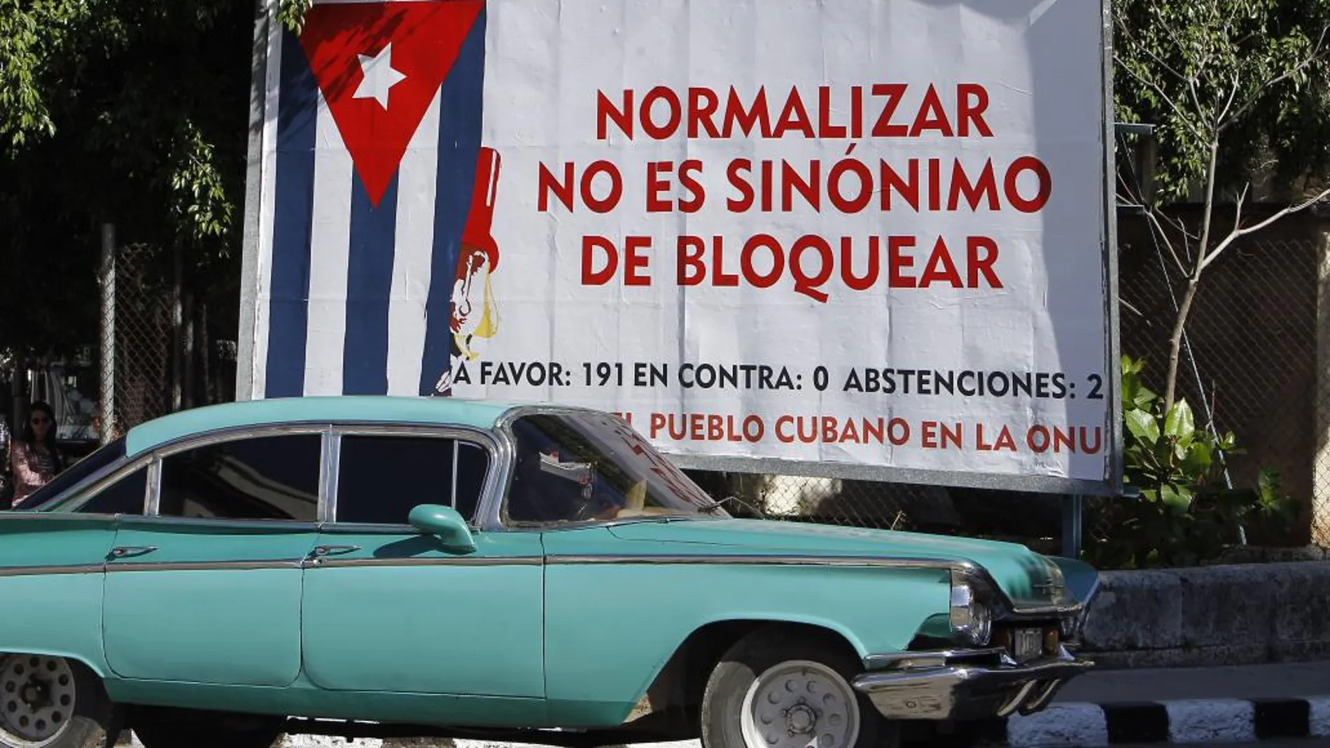 Un coche pasa junto a un cartel alusivo al bloqueo de Estados Unidos contra Cuba, en La Habana (Cuba)