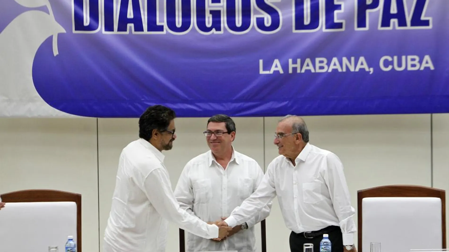 El segundo jefe de las FARC y líder de los delegados de la guerrilla, Luciano Marín (i), alias "Iván Márquez"; saluda al jefe de la delegación de paz del Gobierno colombiano, Humberto de la Calle (d); junto al canciller cubano, Bruno Rodriguez (c)