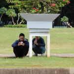 Dos jugadores de Pokémon Go con sus teléfonos en un parque de Yakarta (Indonesia)