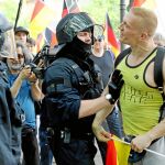 Un simpatizante del partido xenófobo AfD se enfrenta a la Policía alemana que trata de frenar el clima de nerviosismo en las calles de Berlín, donde confluyeron dos marchas de ideas antagónicas