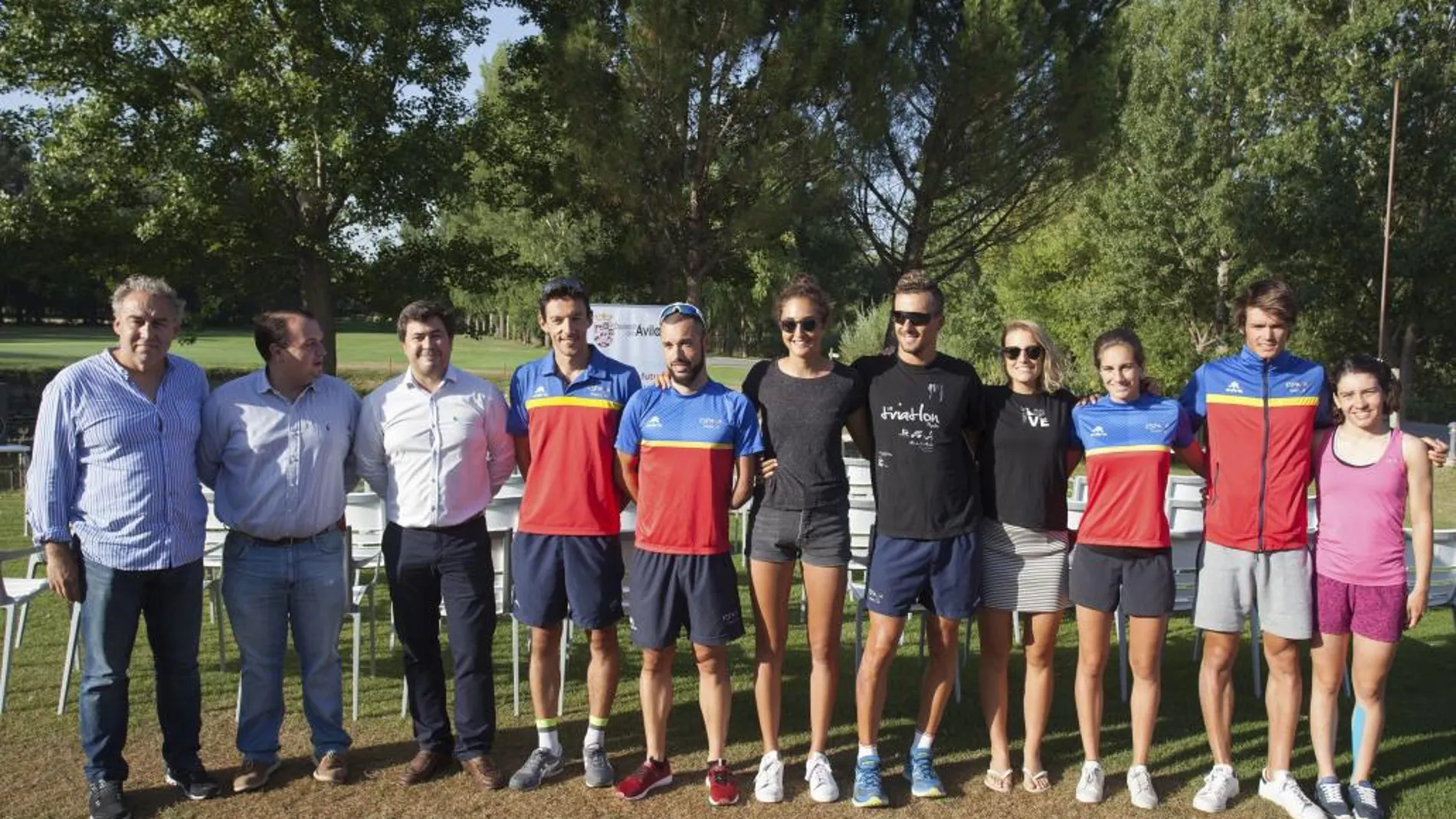 Miembros de la Selección Nacional de Triatlón posan junto a representantes de la Diputación de Ávila, en el complejo deportivo y de ocio de Naturávila donde están concentrados para su preparación