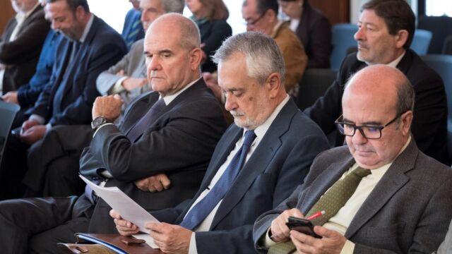 Los ex presidentes de la Junta de Andalucía Manuel Chaves (i) y José Antonio Griñán (c), junto al ex consejero de Presidencia Gaspar Zarrías (d), con Guerrero de fondo