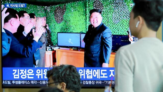 Kim Jong Un muestra el lanzamiento de un misil en un programa de televisión, ayer