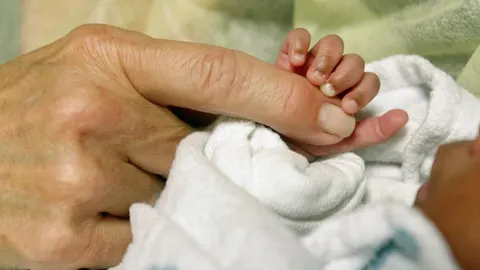 Las manos de un bebé prematuro y su madre en el hospital / AP