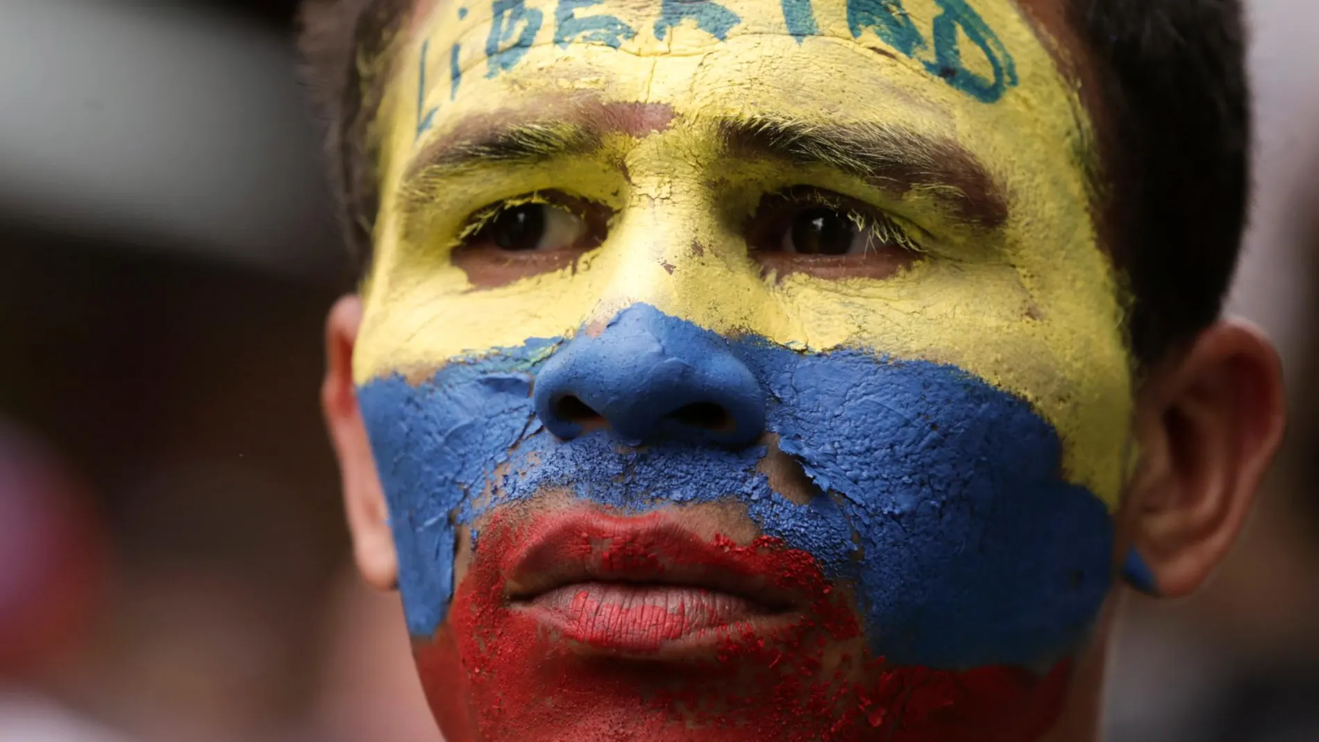 Un opositor venezolano pide libertad con la cara pintada con los colores de la bandera venezolana/AP