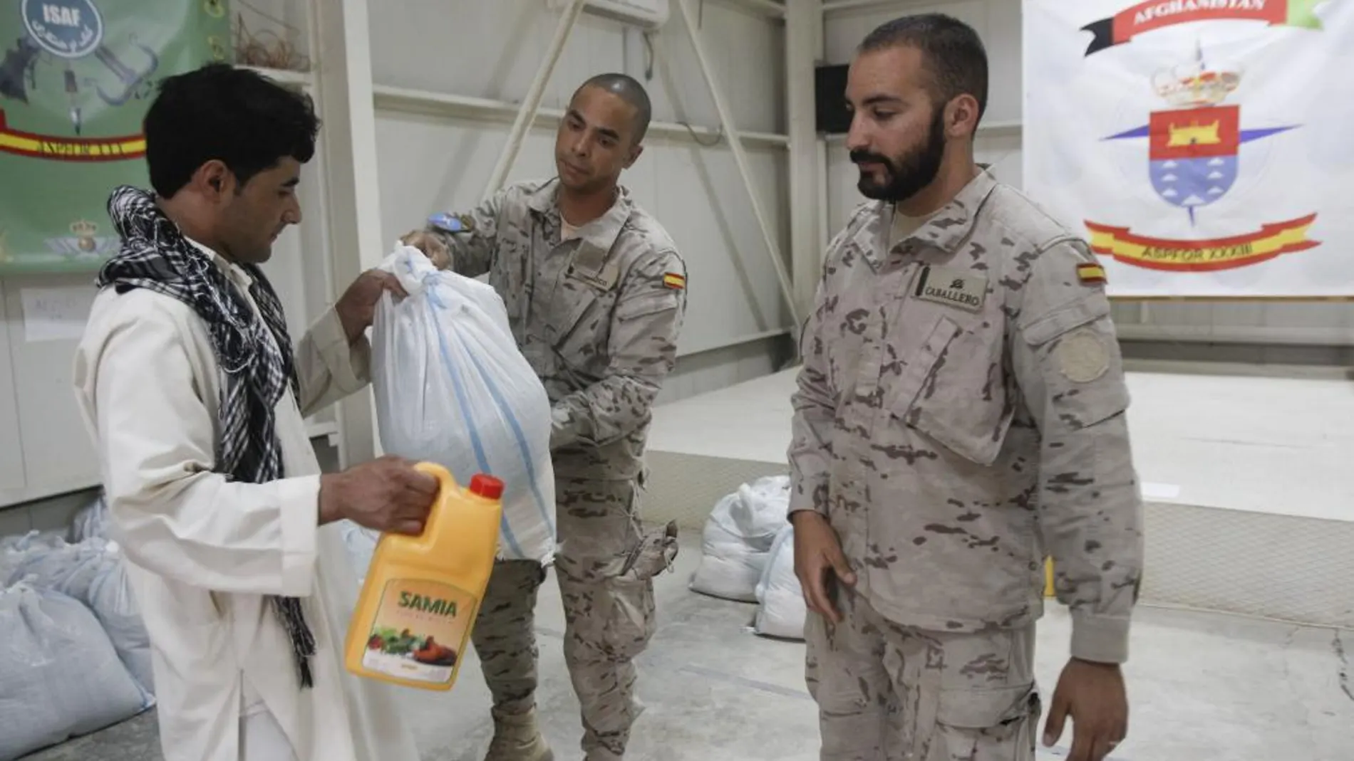 Soldados españoles entregan comida a un afgano
