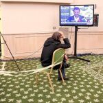 Un hombre ve la televisión mientras espera el comienzo de una rueda de prensa en la sede del Movimiento 5 Estrellas en Roma