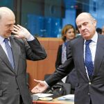Pierre Moscovici, junto al ministro Luis de Guindos, en una de las reuniones del Eurogrupo en Bruselas, en mayo