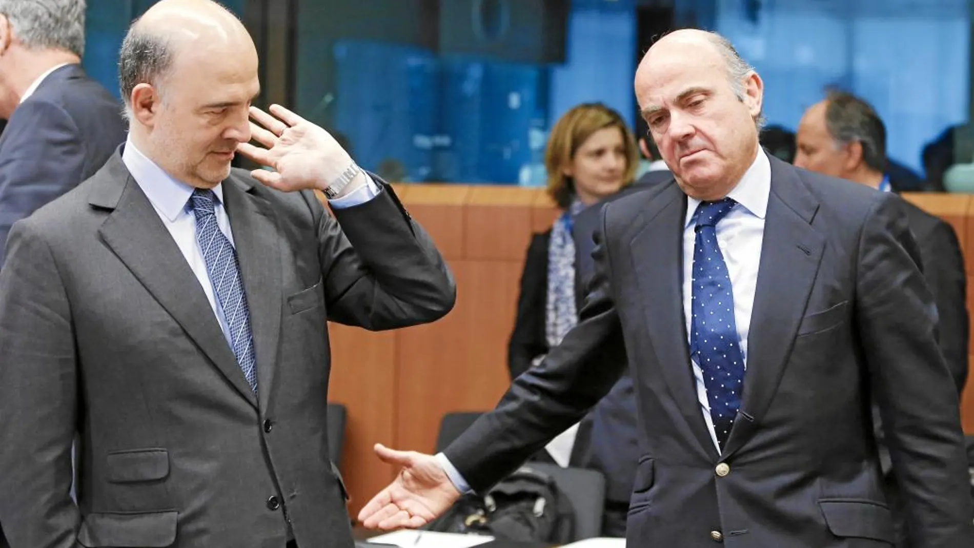 Pierre Moscovici, junto al ministro Luis de Guindos, en una de las reuniones del Eurogrupo en Bruselas, en mayo
