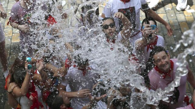 Gente recibe agua desde los balcones y festejan el inicio de las fiestas de San Fermín 2017
