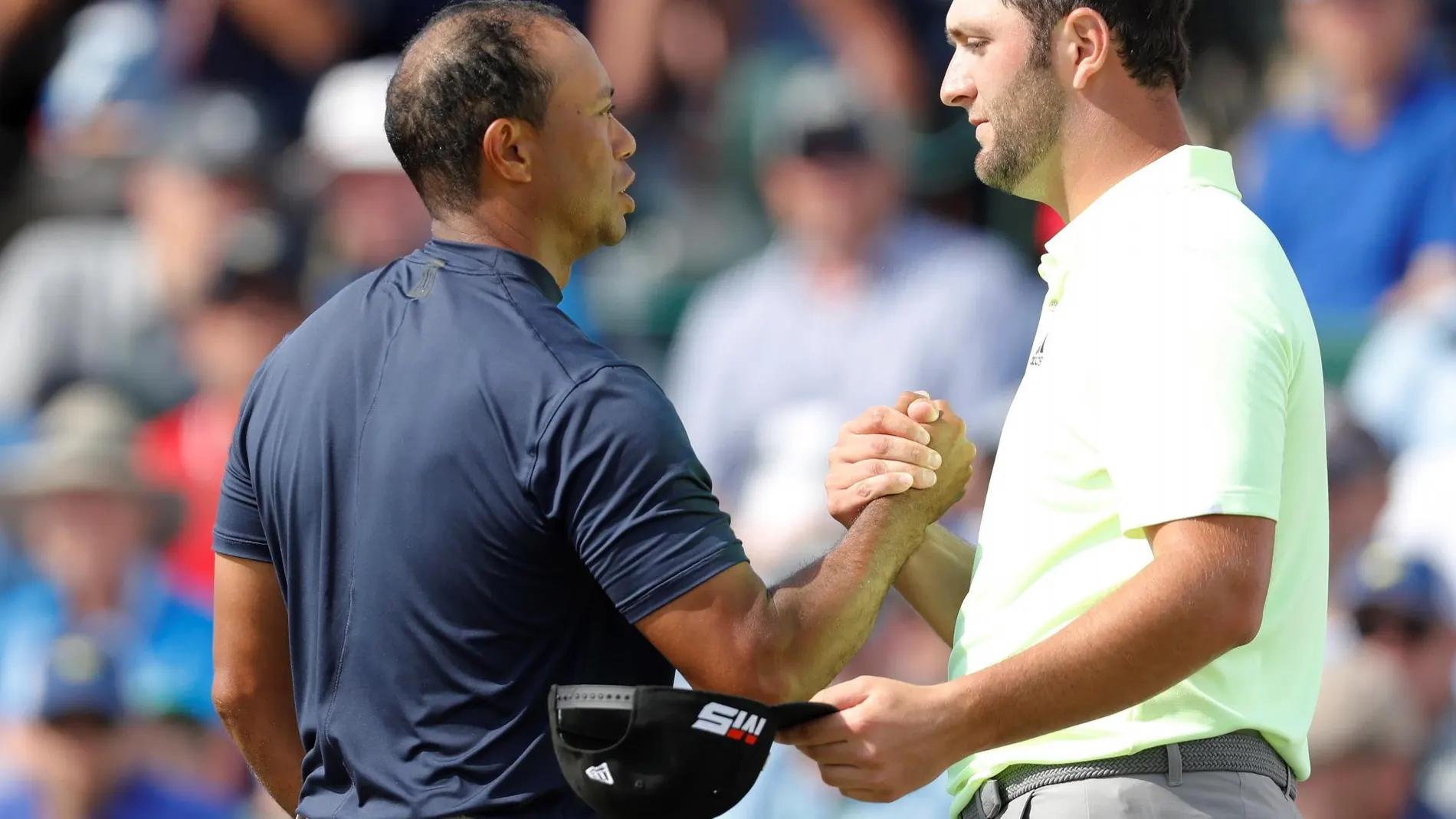 Jon Rahm y Tiger Woods se dan la mano tras la primera jornada