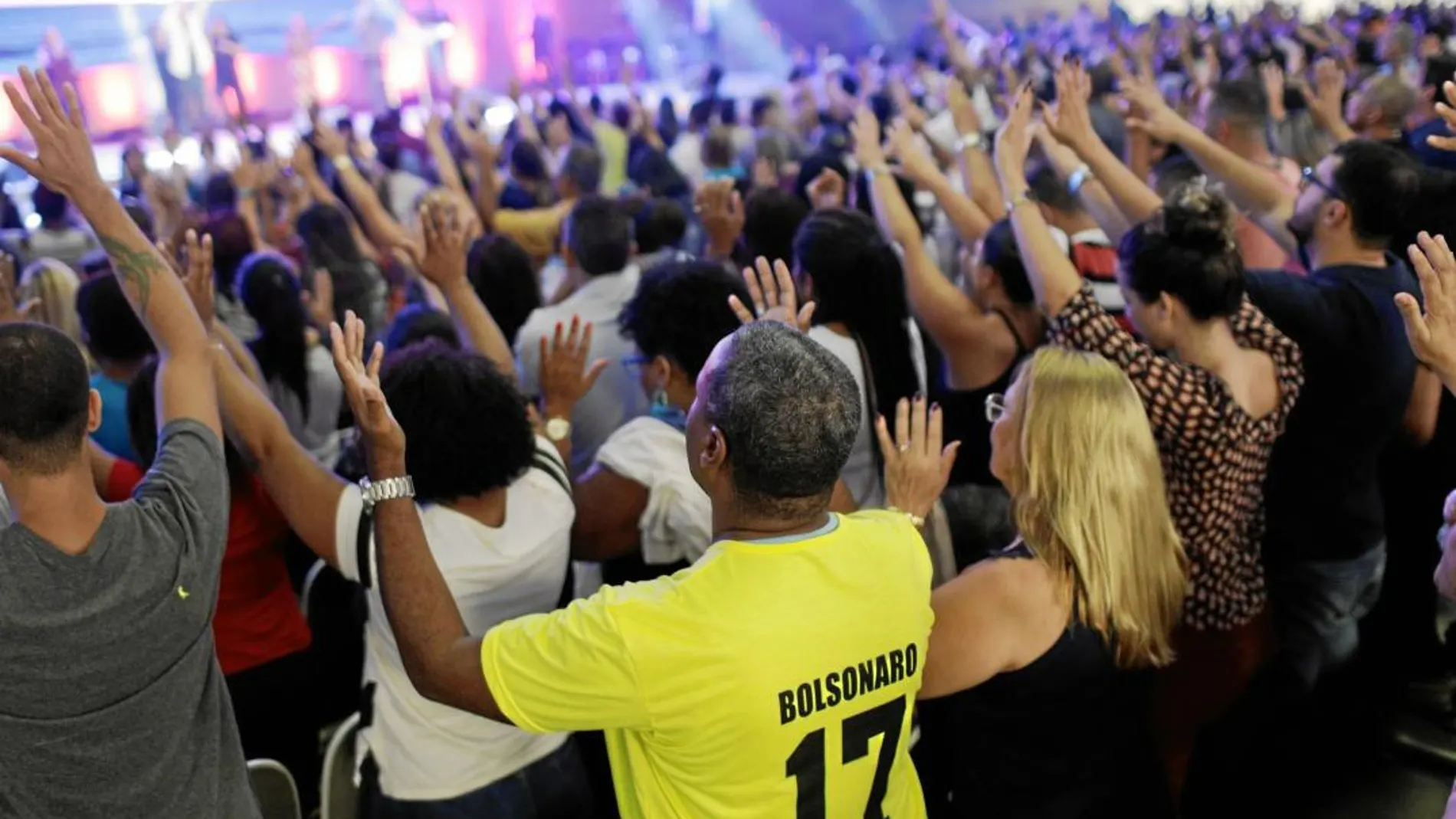 Fieles evangelicos, uno de ellos con una camiseta a favor del candidato ultra, asisten a un servicio religioso de Silas Malafaia en Río de Janeiro