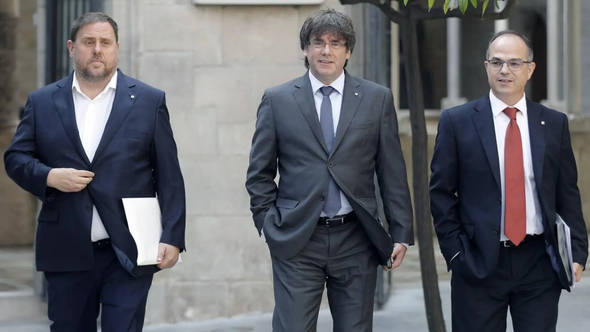 El ex presidente de la Generalitat, Carles Puigdemont (c), junto al ex vicepresidente del Govern, Oriol Junqueras (i), y candidato a la Generalitat, Jordi Turull en una imagen de archivo
