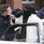 Un agente de policía alemán interroga ayer a un hombre con el rostro tapado antes de subirse en un taxi frente a una mezquita en la calle Perleberger en Berlín (Alemania