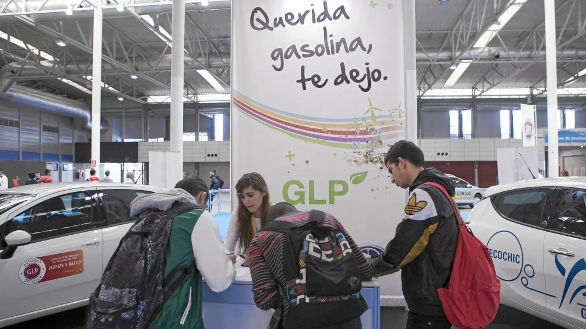 Varios jóvenes rellenan una solicitud para probar un vehículo eléctrico